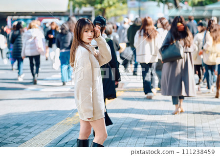 A woman with long hair turns around in the crowds of Shibuya A woman with long hair turns around in the crowds of Shibuya 111238459