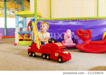 Child Playing with Toy Crane in Playroom 111238634