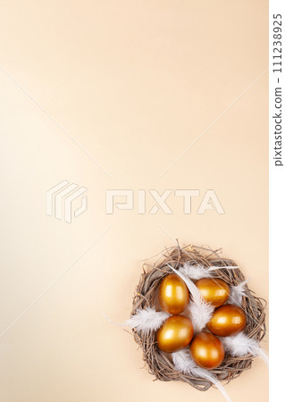 Empty space for text, a banner of happy Easter. Painted golden eggs, white feathers. copy space flat lay top view Vertical nest with eggs Empty space for text, a banner of happy Easter. Painted golden eggs, white feathers. copy space flat lay top view Vertical nest with eggs 111238925