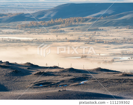 Misty morning mountain valley. Valley with the river in the distance Misty morning mountain valley. Valley with the river in the distance 111239302