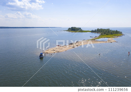 Aerial view of the island's sandy spit with forest and vacationing tourists 111239656