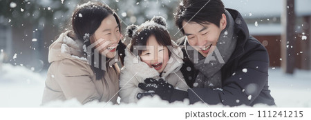 Asian family wearing coats playing in the snow. 111241215