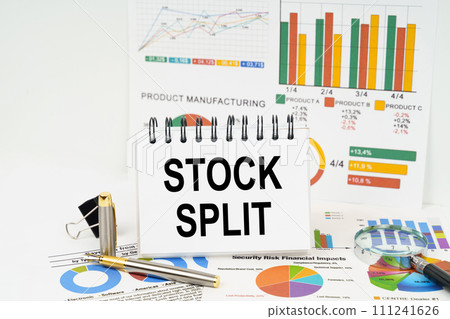 On the table are reports with graphs and a notepad with the inscription - Stock split On the table are reports with graphs and a notepad with the inscription - Stock split 111241626