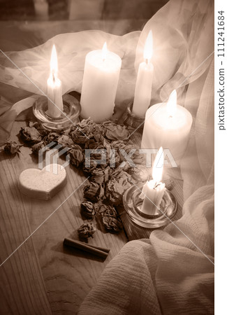 Candles and dried rosebuds on the table Candles and dried rosebuds on the table 111241684