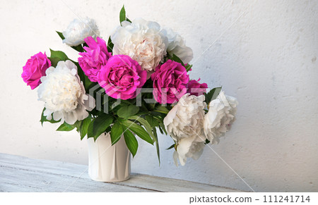 Bouquet of peonies and roses on a table 111241714