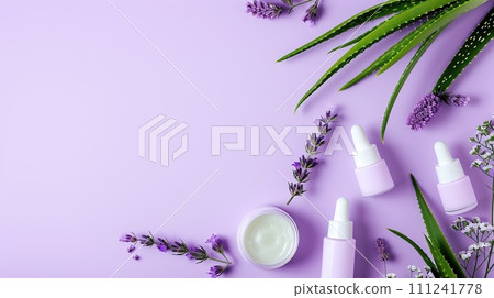 Arrangement of aloe skincare products, delicate containers set with aloe vera leaves on a pastel lavender background 111241778