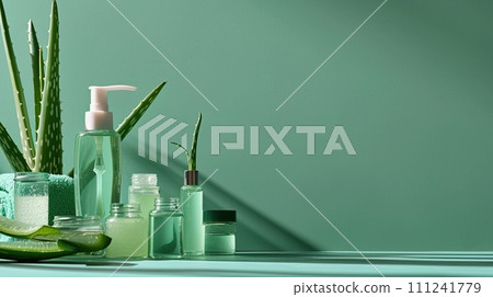 Aloe vera skincare flat lay, bottles and jars on a calming sea green surface with aloe leaves 111241779