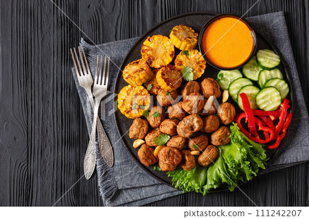 baked meatballs with vegetables and sauce on plate baked meatballs with vegetables and sauce on plate 111242207