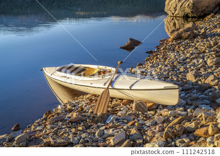 expedition canoe on a shore of Carter Lake in northern Colorado, warm winter afternoon 111242518