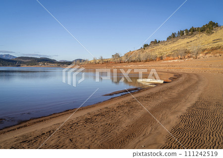 expedition canoe on a shore of Carter Lake in northern Colorado, warm winter afternoon 111242519