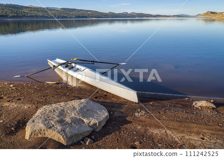 Coastal rowing shell on a shore of Carter Lake in northern Colorado in winter scenery Coastal rowing shell on a shore of Carter Lake in northern Colorado in winter scenery 111242525