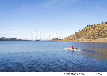 Senior male rower is rowing a coastal rowing shell - Carter in fall or winter scenery in northern Colorado. 111242528