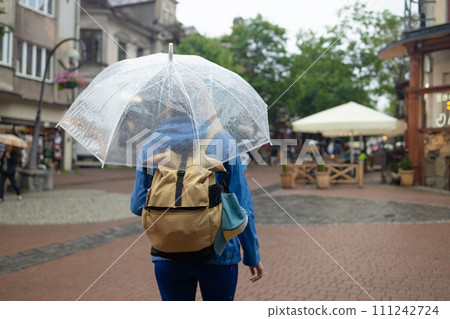 Close up of smiling girl under umbrella in downpour Close up of smiling girl under umbrella in downpour 111242724