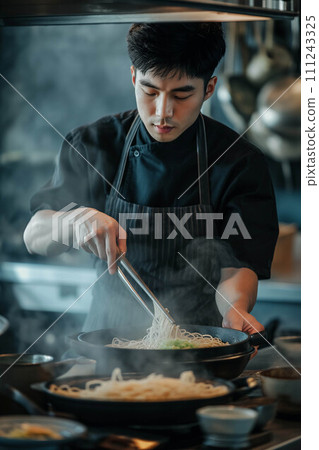 Asian male chef making ramen in the kitchen. Asian male chef making ramen in the kitchen. 111243325