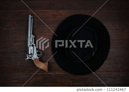 Old west gun and hat on table. Top view. Old west gun and hat on table. Top view. 111243467