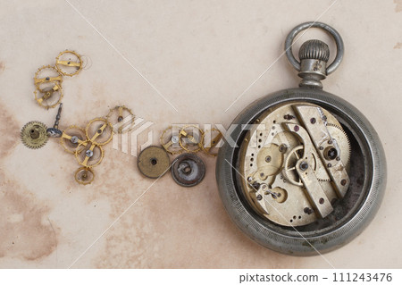 broken vintage pocket watch on dirty paper 111243476