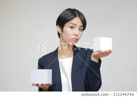 一個拿著兩個方盒子感到困惑的女人_1 一個拿著兩個方盒子感到困惑的女人_1 111244748