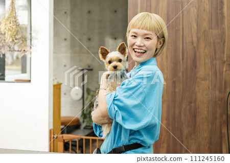 在狗沙龍裡抱著約克夏犬的短髮女人 在狗沙龍裡抱著約克夏犬的短髮女人 111245160