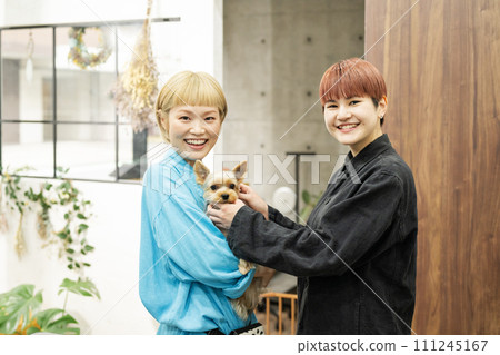 Female staff holding a Yorkshire terrier at a dog salon 111245167