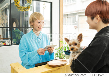 Dog salon, female staff doing accounting Dog salon, female staff doing accounting 111245250
