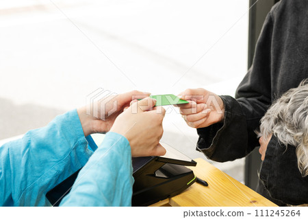 Dog salon, female staff returning credit card 111245264