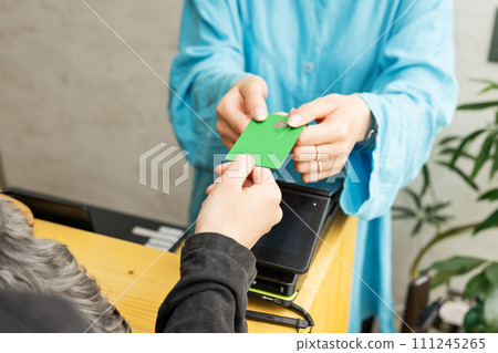 Dog salon, female staff returning credit card 111245265