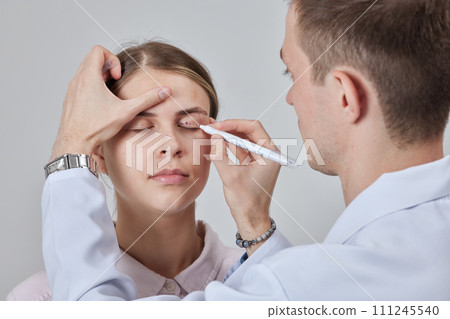 Blepharoplasty of a woman marking on her face before plastic surgery to change the eye area in a medical clinic 111245540