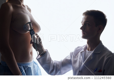 Doctor hand drawing lines on woman breast, breast implant surgery concept. Doctor hand drawing lines on woman breast, breast implant surgery concept. 111245560