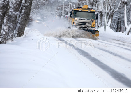 Shoveling snow from the road and blowing snow, snowy roads on a winter day, close-up Shoveling snow from the road and blowing snow, snowy roads on a winter day, close-up 111245641