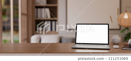 A home office workspace with a laptop on a wooden table in a cosy, Scandinavian living room. A home office workspace with a laptop on a wooden table in a cosy, Scandinavian living room. 111251069