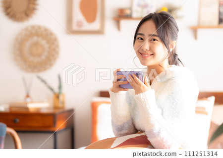 女大學生在床上放鬆，看著智慧型手機 111251314