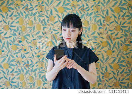 Young woman looking at smartphone screen 111251414