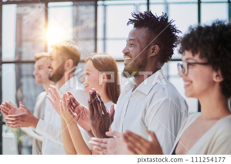 Group of businesspeople sitting in a line and applauding. Group of businesspeople sitting in a line and applauding. 111254177