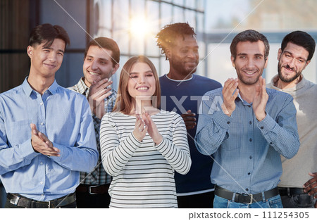 Human resources. Group portrait of smiling employees of a friendly team of different racial genders standing together in an office. 111254305