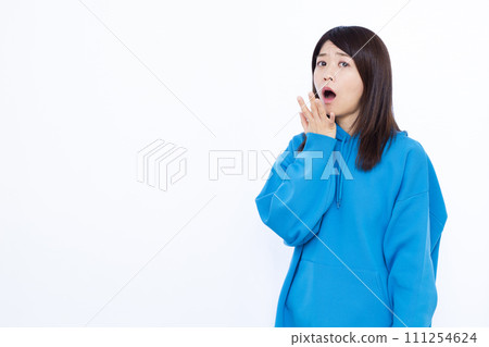 一名 40 多歲的女性，身穿藍色連帽衫，看起來很驚訝 111254624