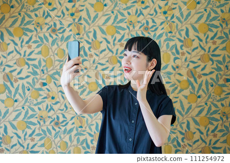 A young woman operating a smartphone 111254972