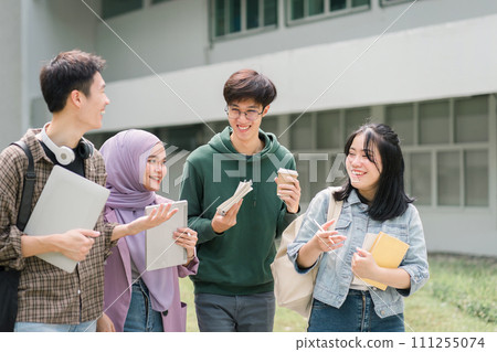 Diverse group of university students walking and talking together on campus. 111255074