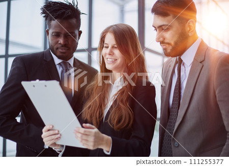 Colleagues Holding Files with Business Report and Reading it Together at Work 111255377