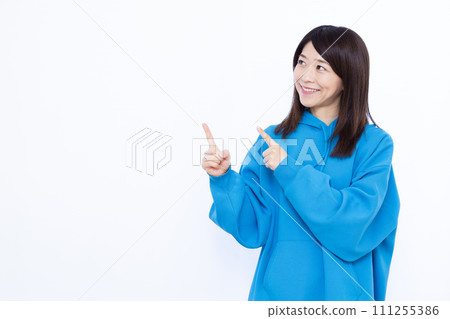 A woman in her 40s wearing a hoodie pointing 111255386