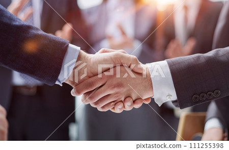 businessman and businesswoman shaking hands in hallway. businessman and businesswoman shaking hands in hallway. 111255398