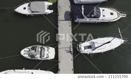 Sailboats moored in the port, a lot of beautiful yachts. Top view on Yachts and boats moored in the port Sailboats moored in the port, a lot of beautiful yachts. Top view on Yachts and boats moored in the port 111255700