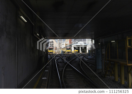 Railway tracks and yellow cars emerging in the darkness, Ueno inspection area on the Ginza subway line 111256325