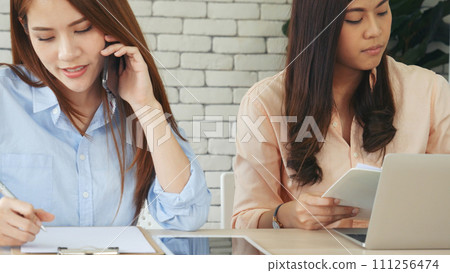 Happy success business woman partner working together in company office corporate executive teamwork. Meeting Executive Asian business woman using laptop office desk with fist arm raised win happiness 111256474