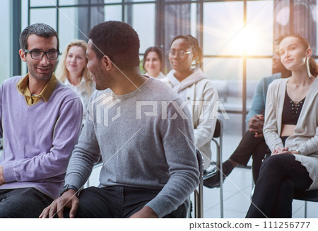 Young men and women listening to a speaker Young men and women listening to a speaker 111256777