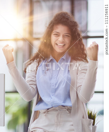 Happy woman screams make a winner gesture with clenched fists 111256911