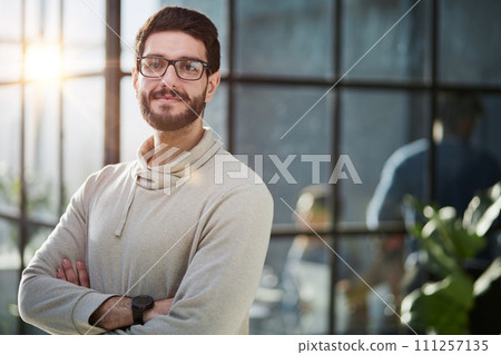Handsome young businessman in smart casual wear keeping arms crossed and smiling 111257135