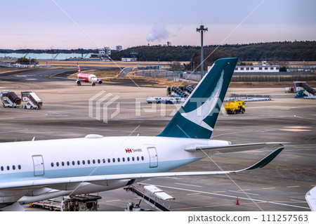 日本千葉市的城市景觀,從成田機場 2 觀看國泰航空和其他航空公司。一架架客機… 日本千葉市的城市景觀,從成田機場 2 觀看國泰航空和其他航空公司。一架架客機… 111257563