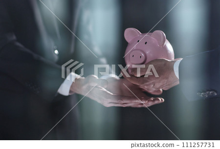 A businessman gives you a piggy bank isolated on a black background. A businessman gives you a piggy bank isolated on a black background. 111257731