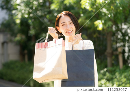 woman holding shopping bags in both hands 111258057