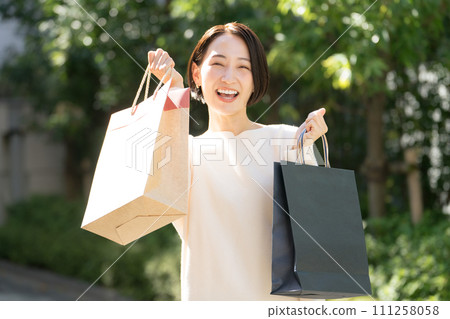 woman holding shopping bags in both hands 111258058